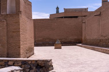 Ortasında küçük taş bir heykel olan tuğla bir duvar.