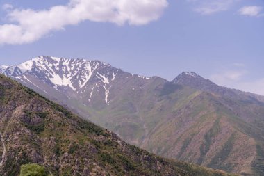 Dağlar karla kaplı ve gökyüzü berrak. Dağlar çok yüksek ve kar çok beyaz.