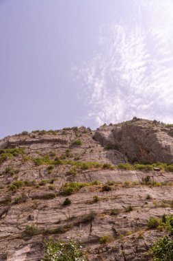 Arka planda mavi gökyüzü olan bir dağ. Gökyüzü açık ve güneş parlıyor.