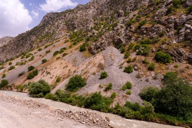 İçinden nehir akan kayalık bir dağ. Nehir temiz ve kayalar tırtıklı. Huzurlu ve huzurlu bir sahne.