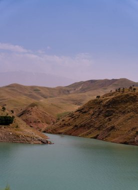 İçinden nehir akan bir dağ sırası. Su berrak ve sakin. Gökyüzü mavi ve hiç bulut yok. Dağlar çimlerle ve ağaçlarla kaplı.