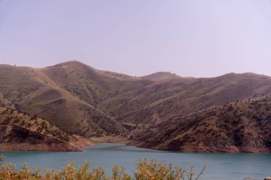 Vadide gölü olan bir dağ sırası. Dağlar ağaçlarla kaplı ve göl sakin.