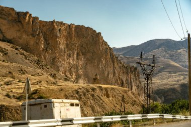 Önünde beyaz bir bina olan çorak bir arazi. Binanın etrafı çitlerle çevrili ve o da bir depo. Manzara ıssız ve çorak, ne bir yaşam ne de bitki örtüsü var.