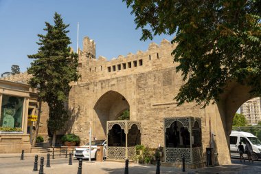 Önünde beyaz bir araba olan taştan bir bina.