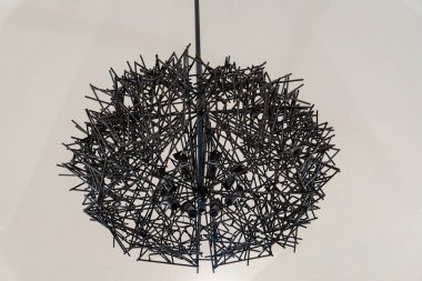 Siyah tabanlı siyah ve beyaz bir abajur. Abajur metalden yapılmış ve dikenli bir tasarımı var.