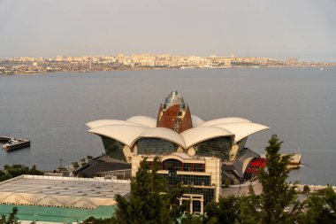 Çiçek gibi bir tasarımı olan büyük bir bina bir tepenin üzerinde su kütlesine tepeden bakar. Bina ağaçlarla çevrili ve o popüler bir turistik ilgi odağı. Huzur ve güzellik kavramı