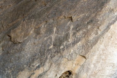 Üzerinde bir sürü yazı olan bir taş. Yazı yabancı bir dilde yazılmış. Kaya çok eski ve çok fazla tarihi var.