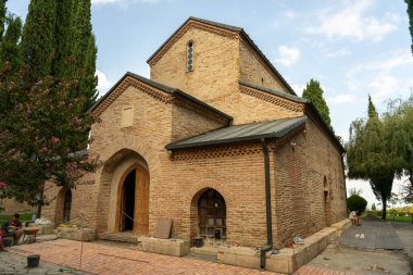 Çan kulesi ve küçük penceresi olan büyük bir tuğla bina. Bina bir kilise gibi görünüyor.