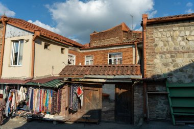 Kırmızı çatılı ve önünde tabela olan küçük bir bina. Binanın bir sürü penceresi ve balkonu var.