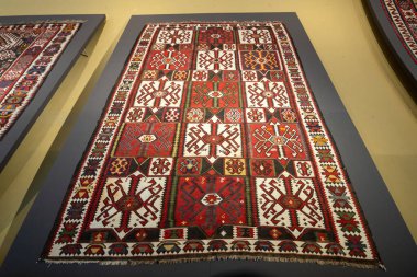 Çiçek ve yıldız desenli renkli bir halı. Halı duvarda asılı. Halı bir sanat eseri.