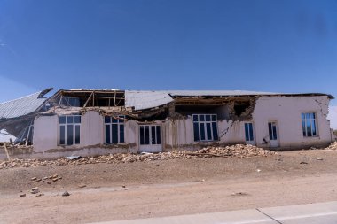 Bir ev enkaz ve molozlarla harabe halinde. Ev çöl bölgesinde.