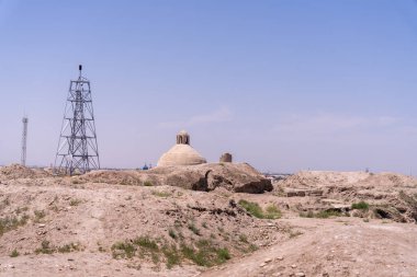Uzakta kulesi olan bir çöl manzarası. Gökyüzü açık ve mavi. Kule bir elektrik santrali.