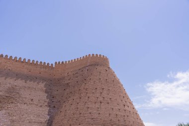 Arka planda mavi gökyüzü olan büyük bir taş bina. Bina eski ve çok detay içeriyor.