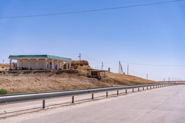 Üzerinde yeşil bir bina olan bir yol. Gökyüzü mavi