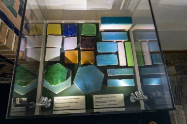 Cam bir kabın içinde renkli fayanslar ve cam parçaları. Görüntü, renklerin ve şekillerin birbirini tamamlayacağı şekilde düzenlenmiştir. Sahne yaratıcılık ve sanatsal ifadelerden biridir.