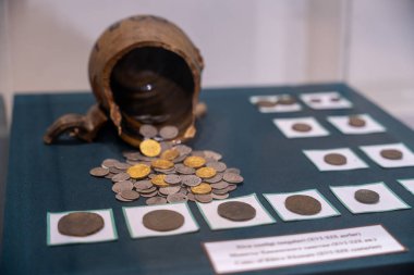 Eski paraların sergilenmesi ve içinden bozuk paraların döküldüğü büyük bir vazo. Madeni paralar Roma İmparatorluğu 'ndan ve M.Ö. 312-M.S. 312 yılları arasındadır.