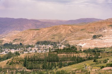 Vadide küçük bir kasabası olan bir dağ sırası. Kasaba ağaçlarla çevrili ve dağlar karla kaplı.