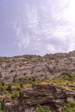Arkasında bulutlu bir gökyüzü olan bir dağ. Gökyüzü mavi ve bulutlar beyaz