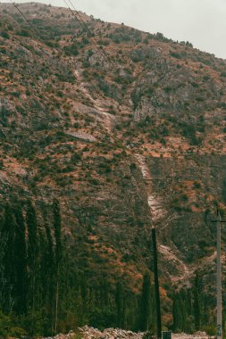 Birkaç ağaç ve elektrik hattı olan bir dağ sırası.