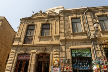 Vitrininde resimler olan bir bina. Bina eski ve bir sürü penceresi var.