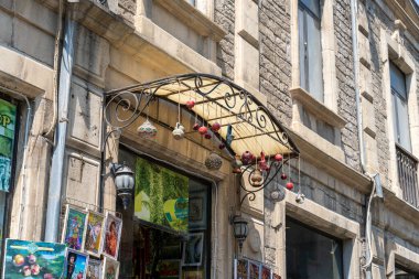 Tentesinden sarkan renkli cam toplarla dolu bir bina. Ekran parlak ve neşeli, toplar da çeşitli boyut ve renklerde.