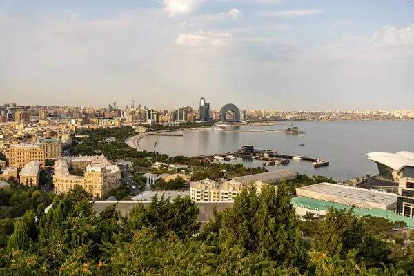 Arkasında büyük bir bina olan bir şehir manzarası. Şehir yaşam ve hareketlilikle dolu.