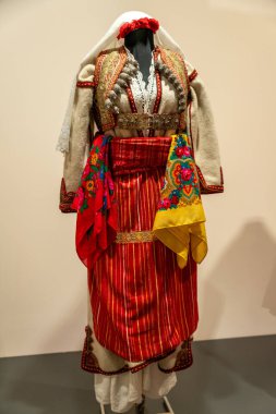 Kırmızı atkısı ve sarı atkısı olan geleneksel kıyafetli bir kadın. Kıyafet yabancı bir ülkeden.