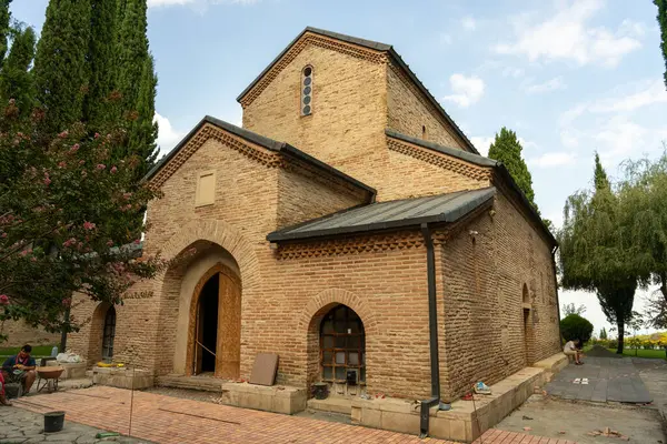 Çan kulesi ve küçük penceresi olan büyük bir tuğla bina. Bina bir kilise gibi görünüyor.