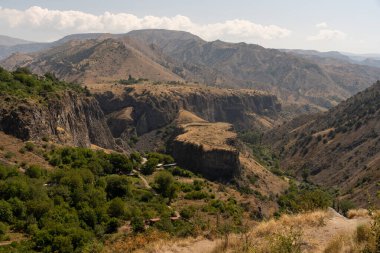 Aralarında vadi olan bir dağ sırası. Vadi kuru ve çorak. Dağlar ağaçlarla çevrili.