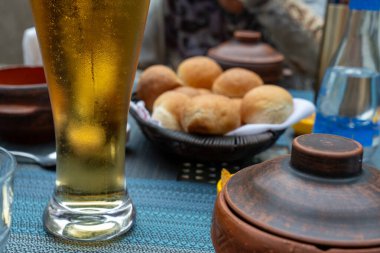 Bir bardak bira bir kase ekmeğin yanındaki masada oturur. Masa yemek için hazır, bir fincan, kaşık ve bir kase ekmek ile. Sahne rahat ve rahat.