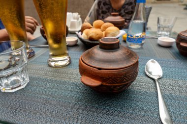 Tencere, kaşık ve bir bardak birayla dolu bir masa. Masa yemek için hazır.