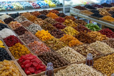 Bir sürü fındık ve kurutulmuş meyve. Görüntü renkli ve davetkar. Fındık ve kuru meyvelerin çeşitliliği etkileyici ve sunum görsel olarak çekici.