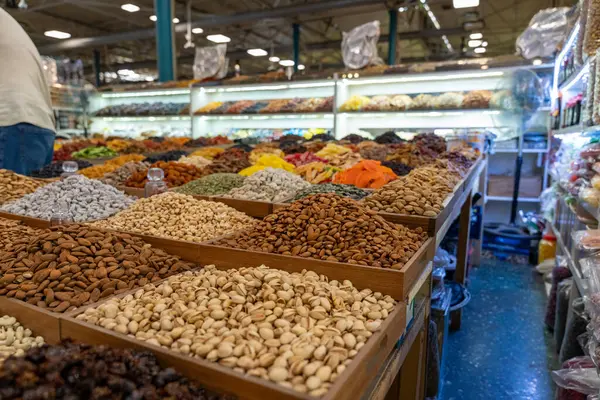 Bir mağazada çok çeşitli fındık ve tohumlar sergilenmektedir. Fındıklar farklı renk ve boyutlarda, ve fındık ve tohumların çok farklı çeşitleri var. Mağaza iyi aydınlatılmış.