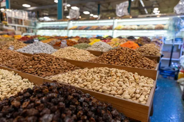 Bir mağazada çok çeşitli fındık ve tohumlar sergilenir. Fındıklar farklı renk ve boyutlarda ve tohumlar da farklı boyutlarda. Görüntü düzenli ve görsel olarak çekici.