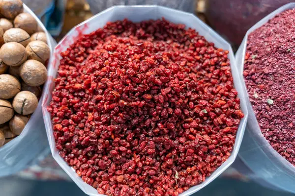 Bir torba kırmızı dut diğer yiyecek torbalarının yanında bir masada oturur. Böğürtlenler üst üste yığılmış ve popüler bir atıştırmalık gibi görünüyor.