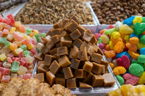 Bir yığın şeker çeşitli renklerde sergilenir. Şeker tepside üst üste birkaç parça şekerle üst üste yığılmış. Şekerler rengarenk ve o da farklı tiplerden.