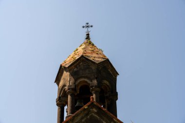 Üstünde haç olan bir kilise kulesi. Gökyüzü açık ve mavi
