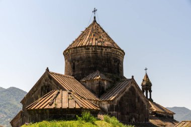 Çan kulesi ve tepesinde haç olan büyük bir bina. Bina eski ve üzerinde bir sürü yosun yetişiyor. Gökyüzü açık ve mavi