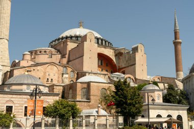 Tepesinde kubbe, tepesinde haç olan büyük bir bina. Bina ağaçlarla çevrili ve fıskiyeli bir avlusu var.