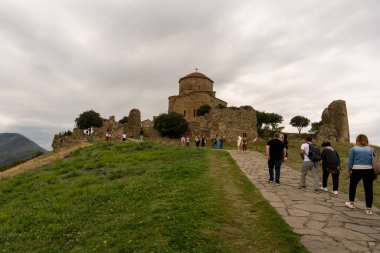 Bir grup insan kalenin yakınındaki bir yolda yürüyor. Kale eski ve bir sürü tarihi var. İnsanlar güzel manzaranın tadını çıkarıyor ve atmosferin tadını çıkarıyorlar.
