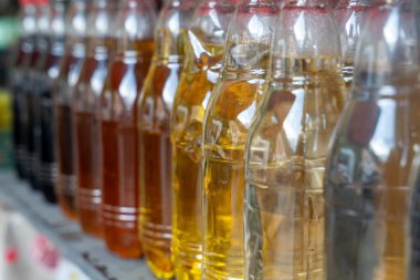 İçinde farklı renkte sıvılar olan bir sıra şişe. Şişeler yan yana dizilmiş.