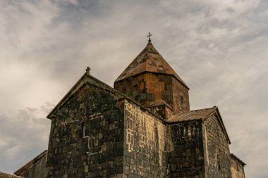 Çan kulesi ve üzerinde haç olan büyük taştan bir bina. Bina eski ve bir tarih anlayışı var.