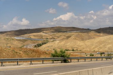 Arka planda uzun bir karayolu olan bir yol. Yol boş ve gökyüzü temiz.