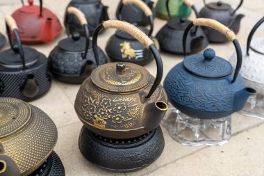 Farklı tasarım ve renklere sahip çaydanlık koleksiyonu. Çaydanlıklar art arda dizilir, bazıları daha uzun, bazıları daha kısadır. Şekillerin çeşitliliği