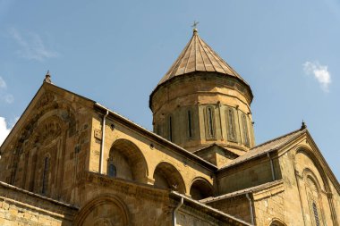 Bina eski ve çan kulesi var. Gökyüzü mavi ve berrak. Bina bir kilise.