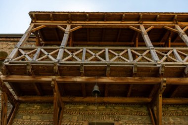 Üzerinde zil olan bir balkon. Balkon ahşap ve kırsal bir hissi var.