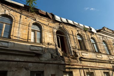 Bir sürü penceresi ve balkonu olan bir bina. Bina bakımsız durumda.