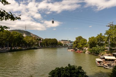 Üzerinde teleferik olan bir nehir. Teleferik suyun üstünde ve nehir yeşil.