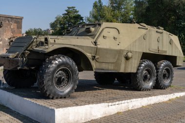Altı tekerli büyük bir askeri araç beton bir levhanın üzerine park edilmiş. Araç kir içinde ve o yaşlı.