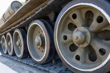 Tankın tekerlekleri, beyaz teller ve siyah jantlar. Tekerlekler büyük ve iyi durumda görünüyor. Tank büyük ihtimalle askeri bir araç.